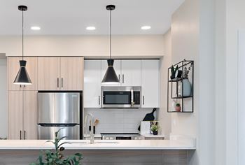 a kitchen with white cabinets and a stainless steel refrigerator and microwave